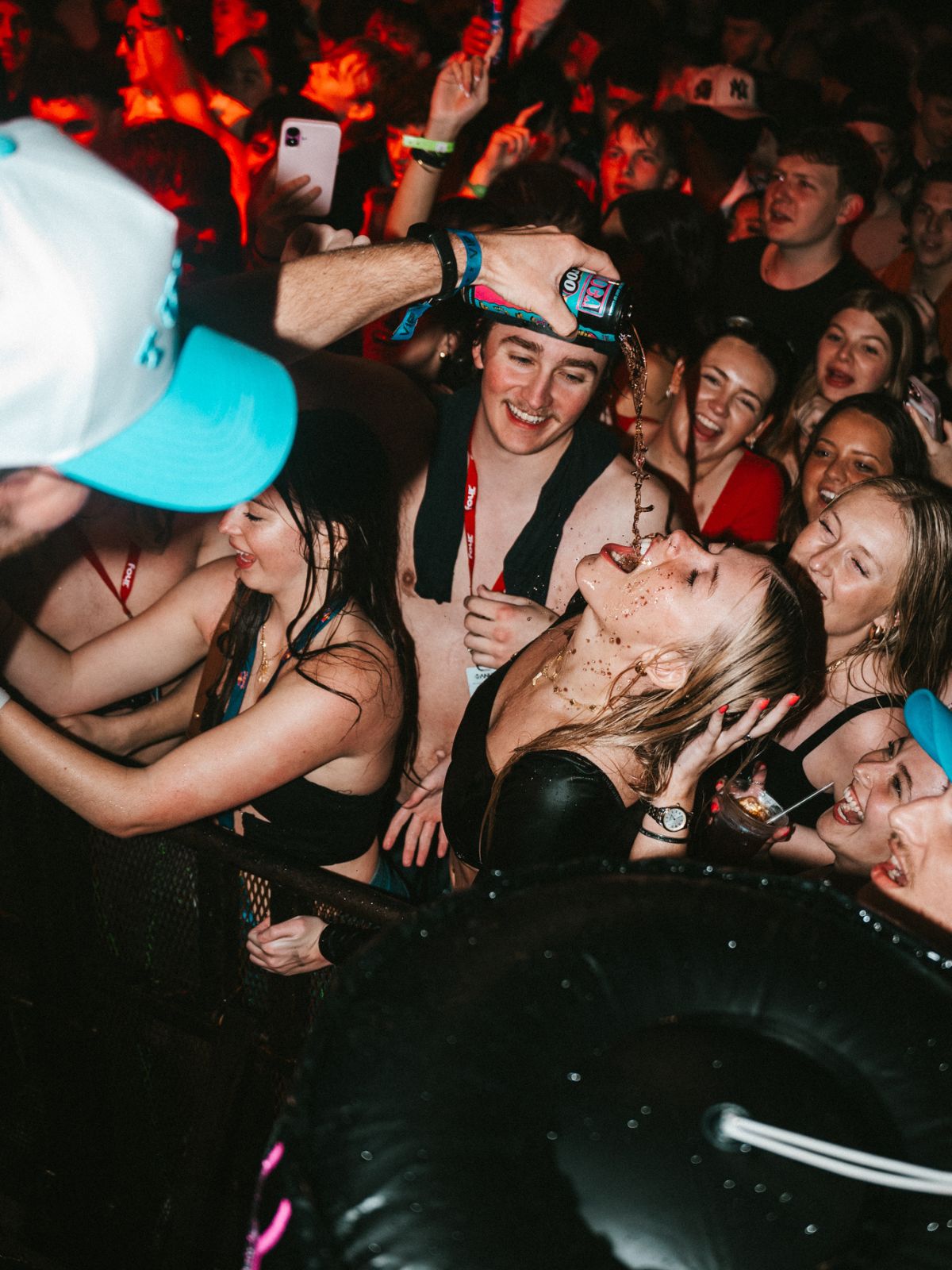 People at a concert or party with a focus on a woman being held by a man.