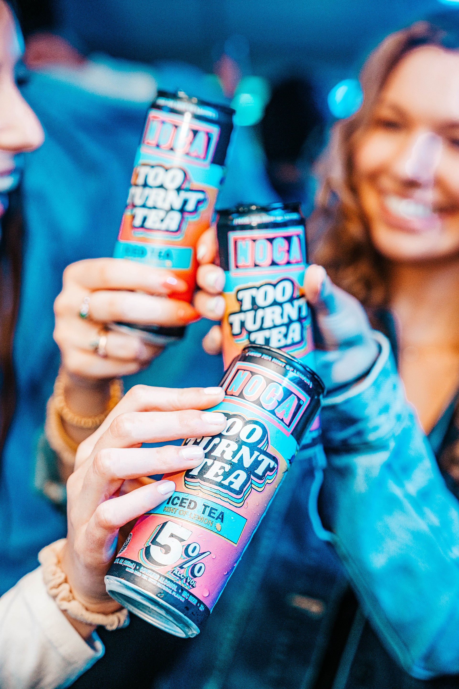 Group of friends laughing together and showing off NOCA cans