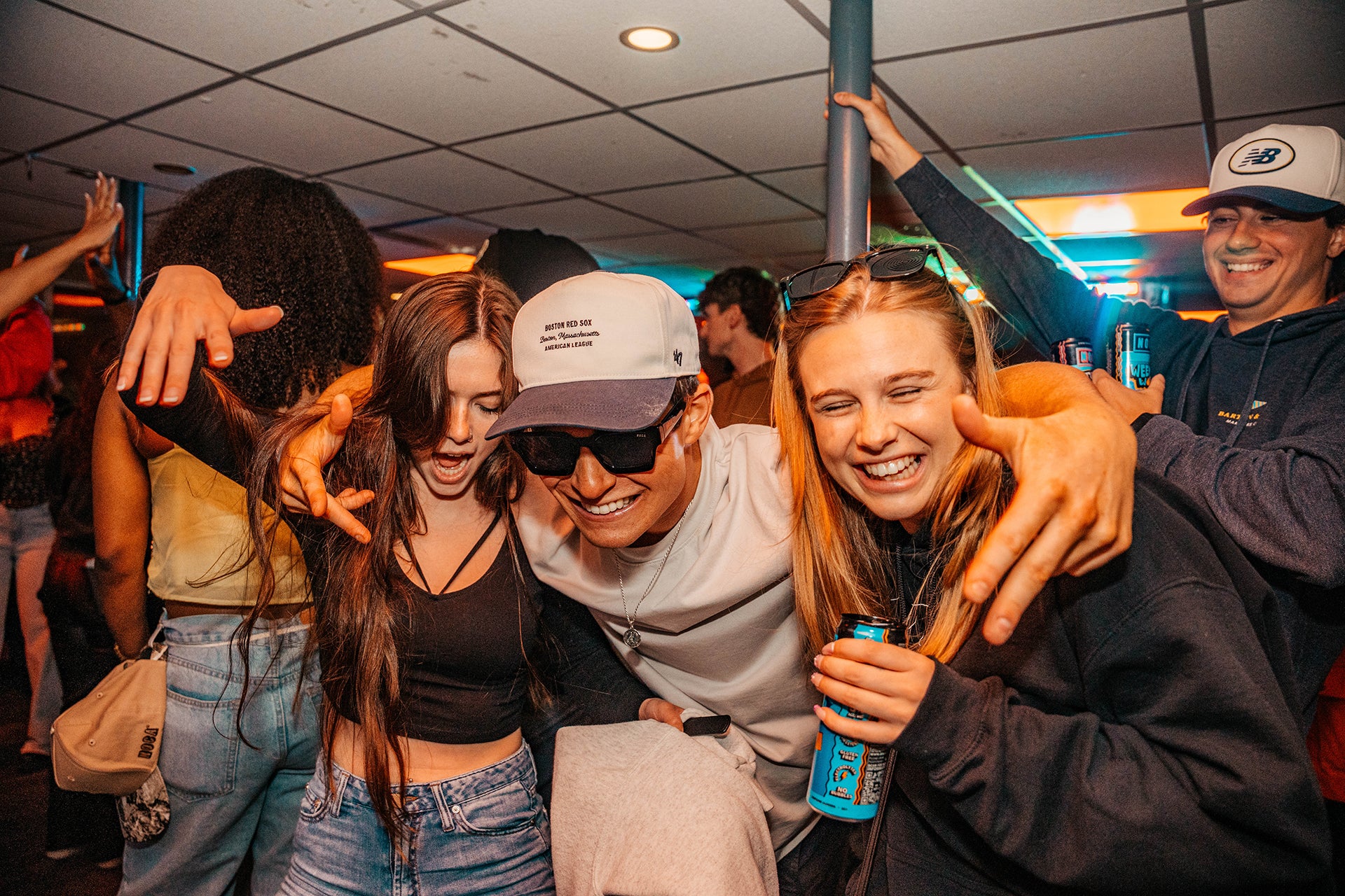 Group of friends singing and laughing  with drinks in their hands